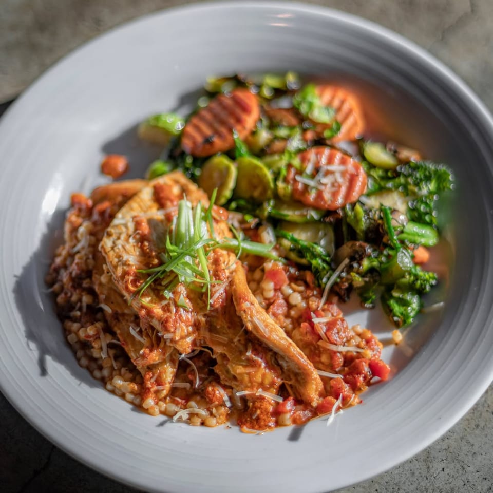 Chicken with tomato sauce over pasta, served with roasted carrots, Brussels sprouts, and broccoli.